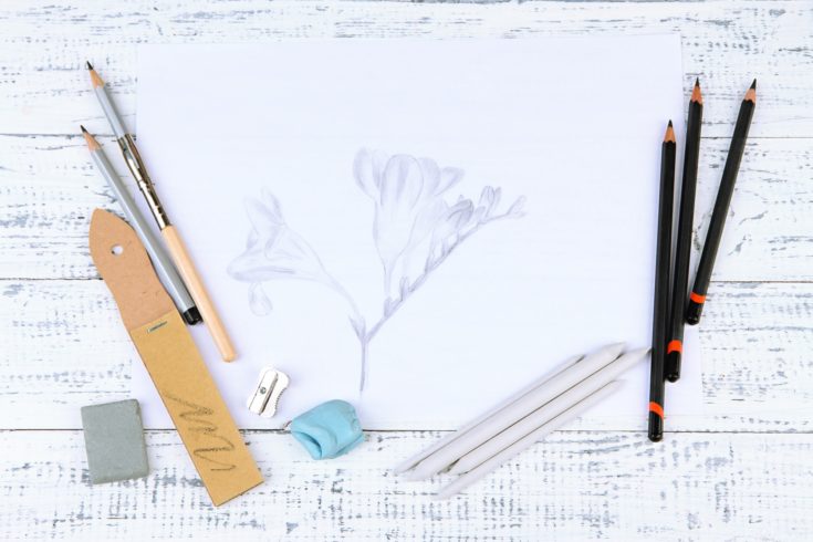 Professional art materials and sketch, on wooden table